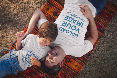 Dad and Boy Wearing T-Shirts Mockup Lying Down at the Park