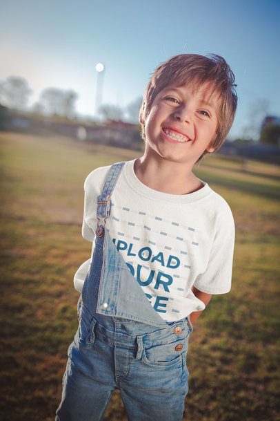 Smiling Kid Wearing a T-Shirt Mockup at a Park