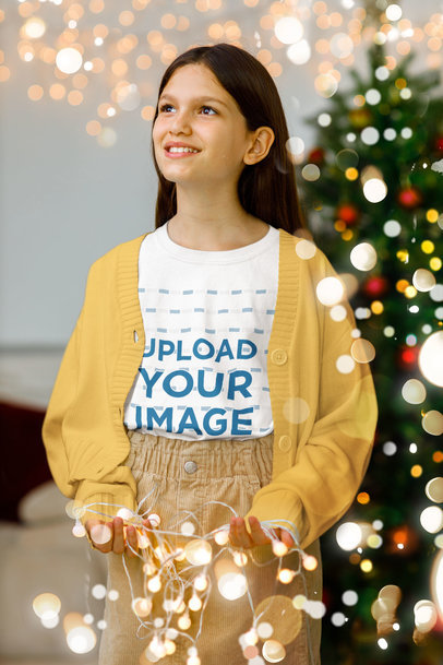 Round-Neck Tee Mockup of a Smiling Girl Holding Christmas Lights