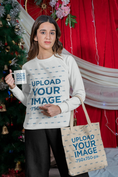Sweatshirt Mockup of a Woman Carrying a Tote Bag and a Mug Featuring a Christmas Setting