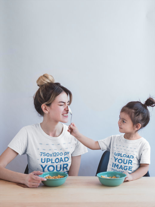 Mom and Daughter Wearing T-Shirts Mockup During a Fun Breakfast