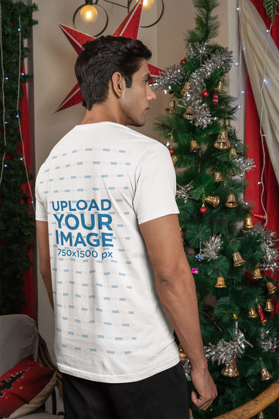 Back-View Tee Mockup Featuring a Man Standing by Christmas Tree m30610