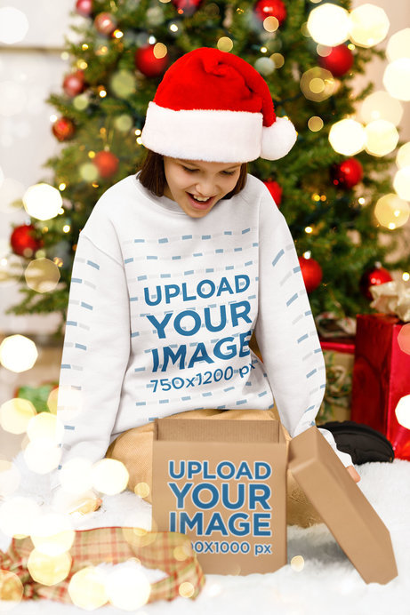 Sweatshirt Mockup of a Joyful Girl Opening a Christmas Present