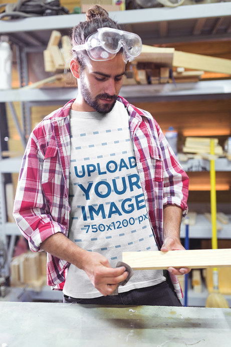 Portrait of a Carpenter Wearing a T-Shirt Mockup While Sanding Wood