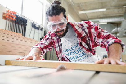 Carpenter Wearing a T-Shirt Mockup while Cutting Wood a20168