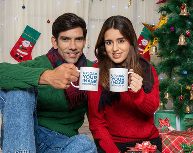 Mockup of a Happy Couple Holding Coffee Mugs in a Christmas Reunion