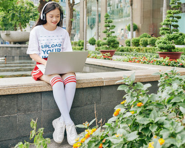 T-Shirt Mockup of a Teenage Girl Working on her Laptop