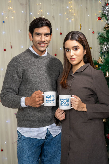 Mockup of a Man and a Woman With Coffee Mugs While Posing in a Christmas Setting