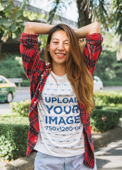 T-Shirt Mockup Featuring a Cheerful Woman Posing in the Street