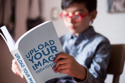 Closeup Shot Mockup of a Book Read by a Boy with Red Glasses