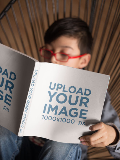 Mockup of a Kid with Glasses Reading a Square Book