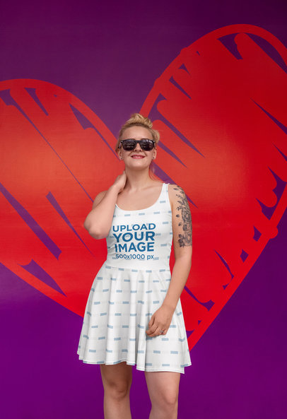 Skater Dress Mockup Featuring a Happy Tattooed Woman Posing Against a Heart-Themed Wall