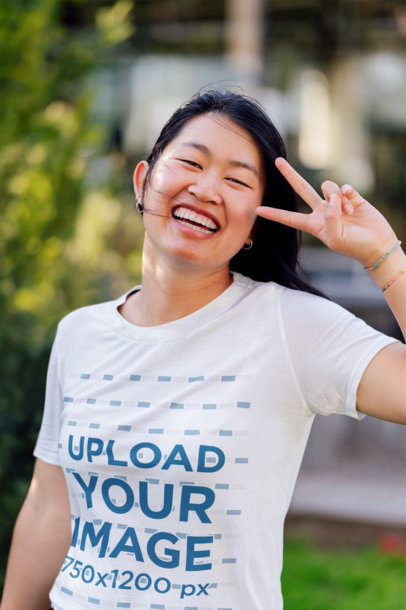 T-Shirt Mockup Featuring a Cheerful Woman Doing the Peace Sign