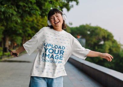 T-Shirt Mockup of a Cheerful Woman Listening to Music While Dancing
