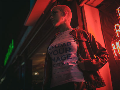 Mockup of a Woman Wearing a Round Neck Tee Outside a Restaurant at Night