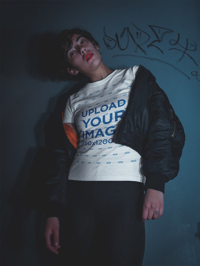 Mockup of a Woman Wearing a Tshirt Standing Against a Gray Wall