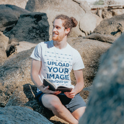 T-Shirt Mockup of a Man Sitting on a Rock and Reading the Bible  m30606 r-el2