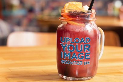 Mockup of a Mason Jar Filled with an Orange Juice
