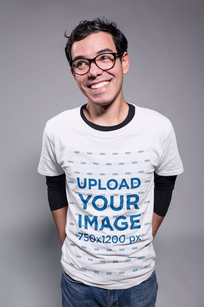 Smiling Nerd Guy Wearing a Tshirt Mockup in a Gray Room