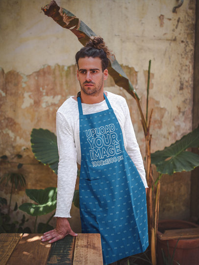 Man Wearing an Apron Template Leaning Against a Table Near a Plant a19881