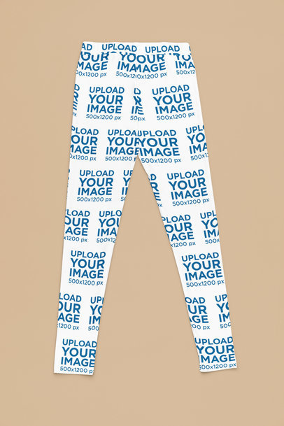 Mockup of a Pair of Sublimated Leggings Flat Laid over a Solid Surface