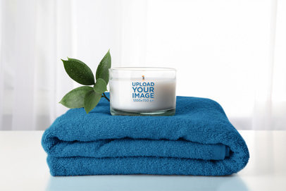 Mockup of a Candle Placed Over a Folded Towel m30384 r-el2