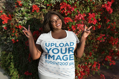 Woman Wearing a Plus Size Tee Mockup Against Red Flowers