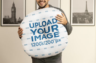 Mockup of a Smiling Man Holding a Floor Pillow
