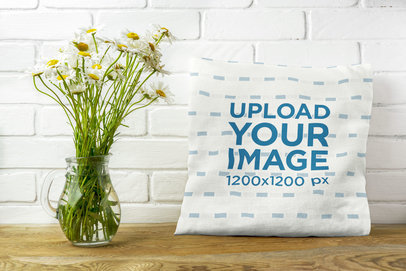 Mockup of a Square Pillow Placed Next to a Flower Vase