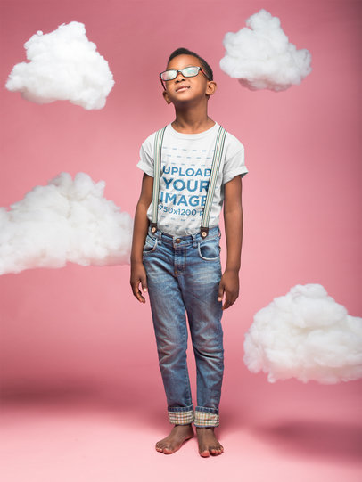 Mockup of a Boy Wearing a T-Shirt in a Pink Room with Clouds