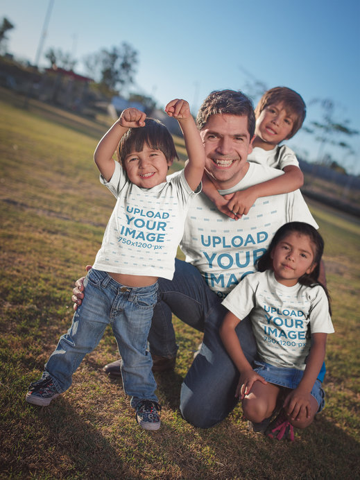 Mockup Featuring a Dad with Kids Wearing T-Shirts Playing at the Park