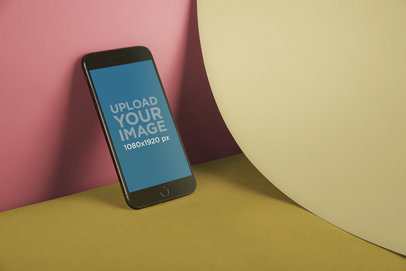 iPhone 8 Mockup Lying Against a Wall Near a Bent Paper