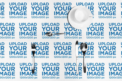 Mockup of a Tablecloth Featuring a Tea Cup and a Cutlery Set