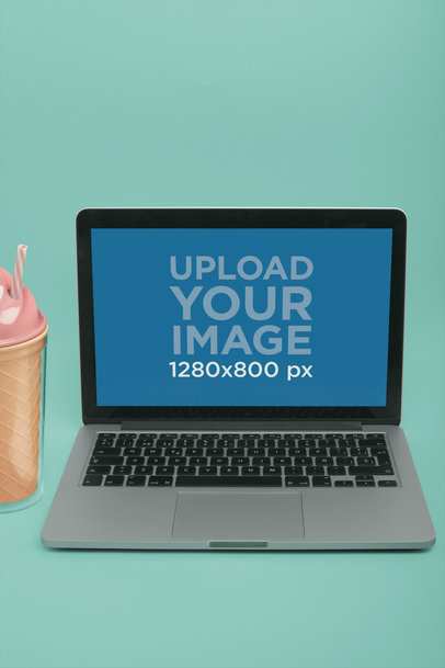 MacBook Mockup on a Solid Surface Near a Plastic Ice-Cream Shaped Tumbler a20341