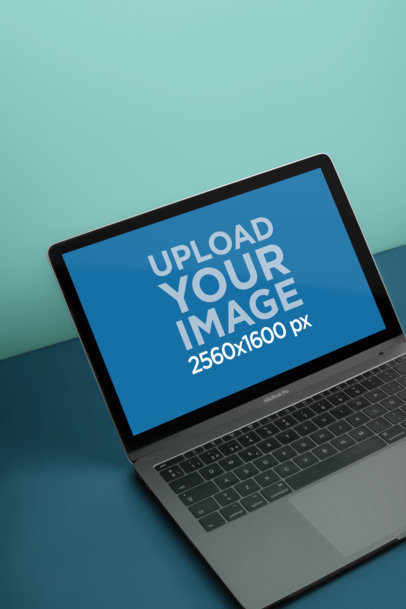 Mockup of a MacBook Lying Against a Wall