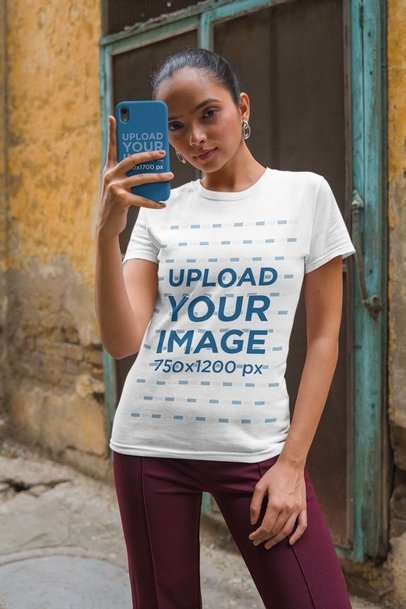 T-Shirt and Phone Case Mockup Featuring a Serious Woman Taking a Selfie
