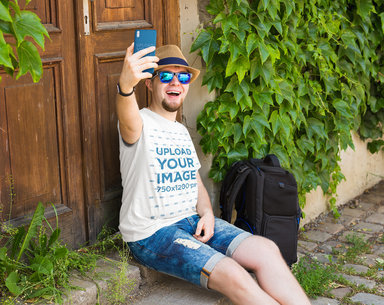 T-Shirt and Phone Case Mockup of a Bearded Man With Sunglasses Taking a Selfie