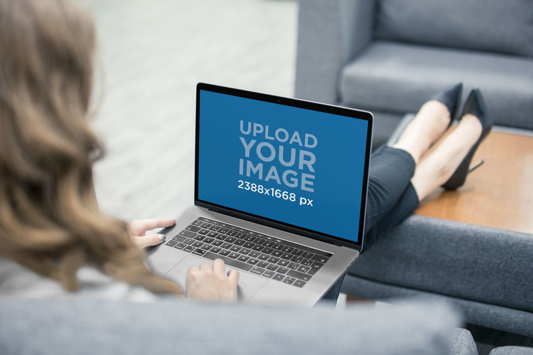 Over the Shoulder Shot Mockup Featuring a MacBook Used by a Blonde Woman in an Office