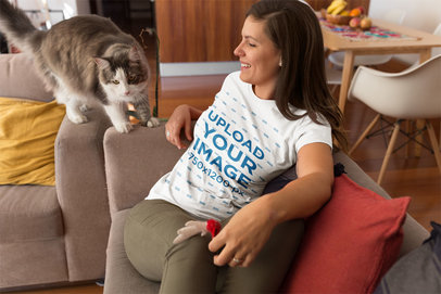 Woman Wearing a T-Shirt Mockup While her Cat Walks on the Sofa