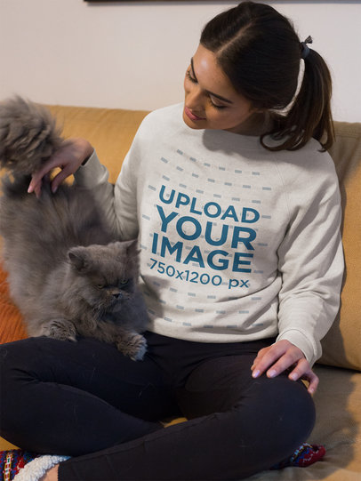 Woman Petting her Cat Wearing a Sweater Mockup on the Sofa