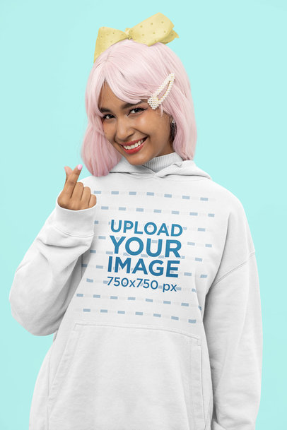 Hoodie Mockup Featuring a Cheerful Woman Doing a Heart Sign With Her Hands