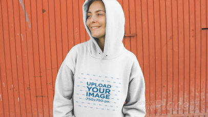 Woman Wearing a Hoodie Video Standing Against a Red Metal Door