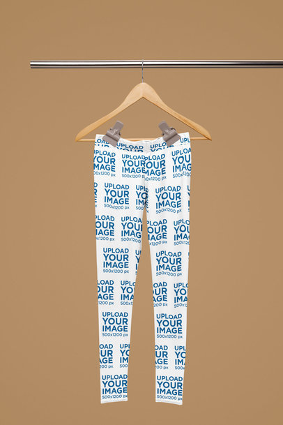 Mockup of a Sublimated Pair of Leggings Hanging from a Steel Bar