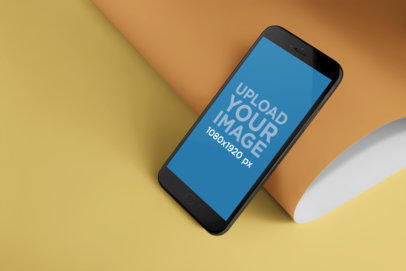 Mockup of an iPhone 8+ Lying Against a Bent Paper