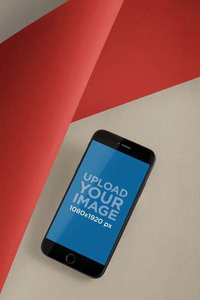 Mockup of a Space Gray iPhone 8 Lying on a Multi-Layered Surface