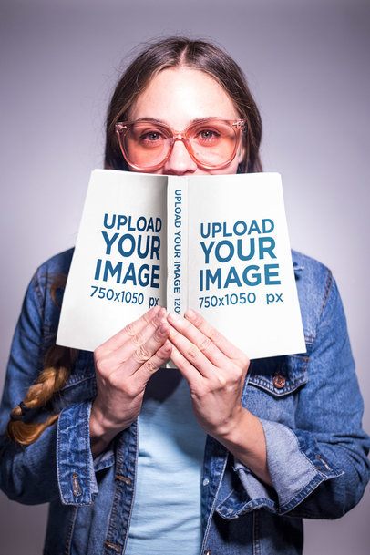 Woman with Glasses and Braids Holding an Open Book Mockup Against her Face a19256