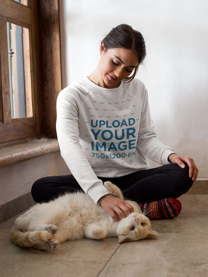 Mockup of a Woman Wearing a Crewneck Sweater While her Cat Does Barrel Roll