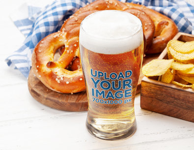 Oktoberfest-Themed Mockup of a Full Beer Glass Placed by Fresh-Baked Pretzels m31535 r-el2