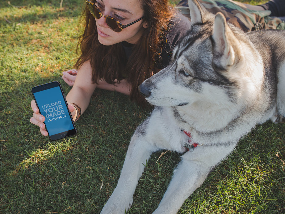 Woman with her Dog Holding an iPhone Mockup Looking Away