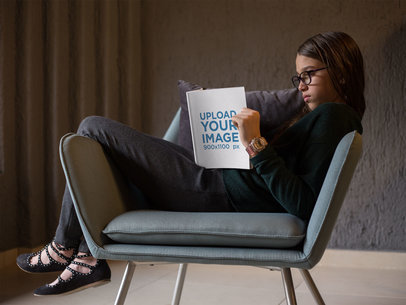 Kid Reading a Book Mockup Sitting on a Vintage Armchair